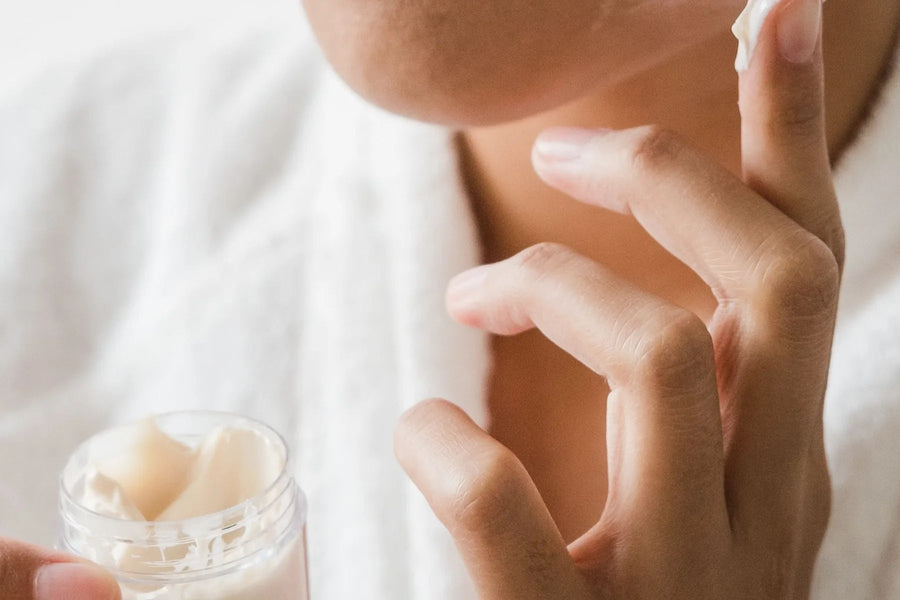 Woman applying moisturizer gently to her cheek