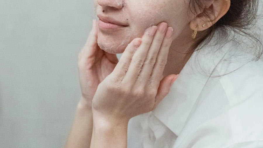Woman gently cleansing her face with fingertips