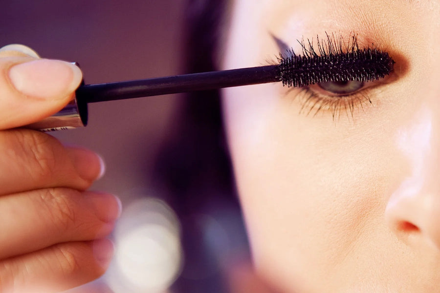 Close-up of black mascara being applied to upper eyelashes